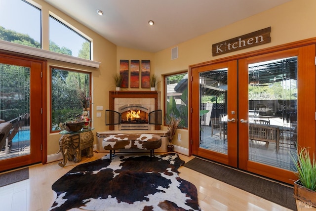 doorway with a wealth of natural light, vaulted ceiling, and wood finished floors