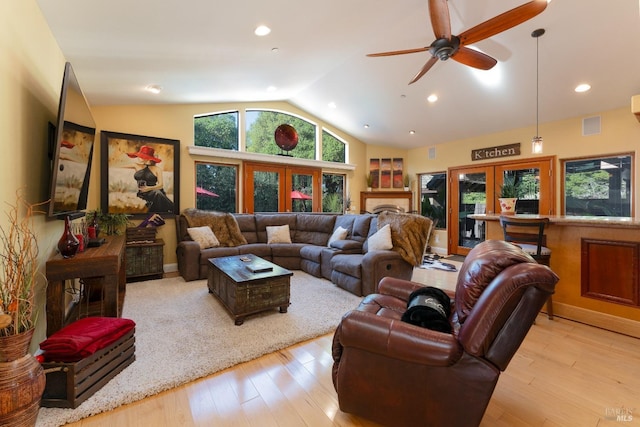 living room featuring lofted ceiling, visible vents, ceiling fan, and hardwood / wood-style flooring