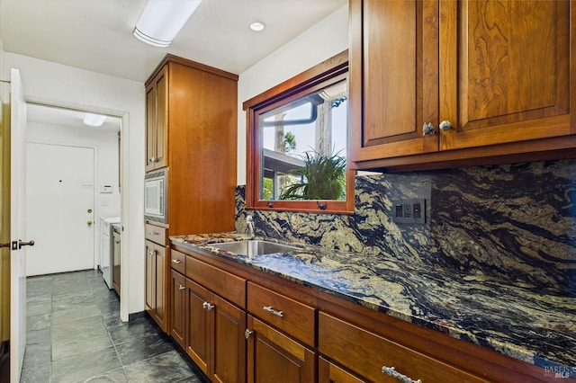 2300 S St, Eureka, CA 95501 - kitchen with a sink, stainless steel microwave, decorative backsplash, dark stone countertops, and brown cabinetry