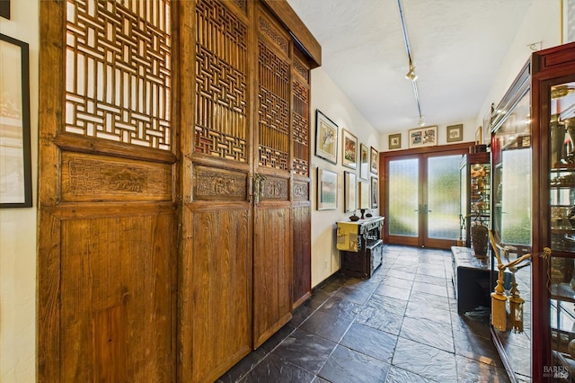 2300 S St, Eureka, CA 95501 - hallway featuring french doors, stone tile flooring, baseboards, and rail lighting