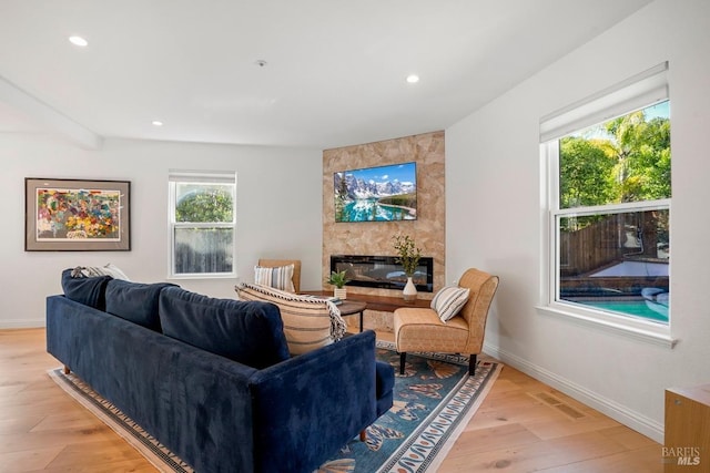 living area featuring visible vents, light wood-style flooring, baseboards, and recessed lighting