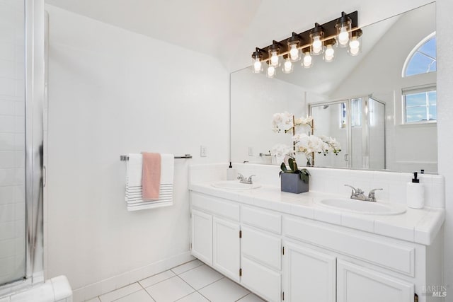 full bathroom featuring a shower stall, tile patterned floors, double vanity, and a sink