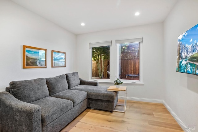 living room featuring baseboards, light wood-style floors, and recessed lighting