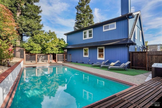back of house featuring a fenced backyard and a fenced in pool