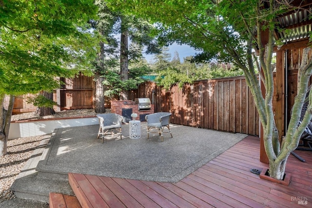 wooden deck with area for grilling and a fenced backyard