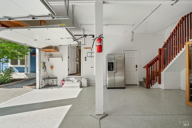 garage featuring stainless steel fridge with ice dispenser