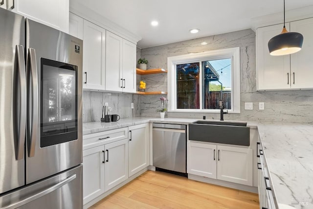 kitchen featuring a sink, decorative backsplash, white cabinets, and appliances with stainless steel finishes