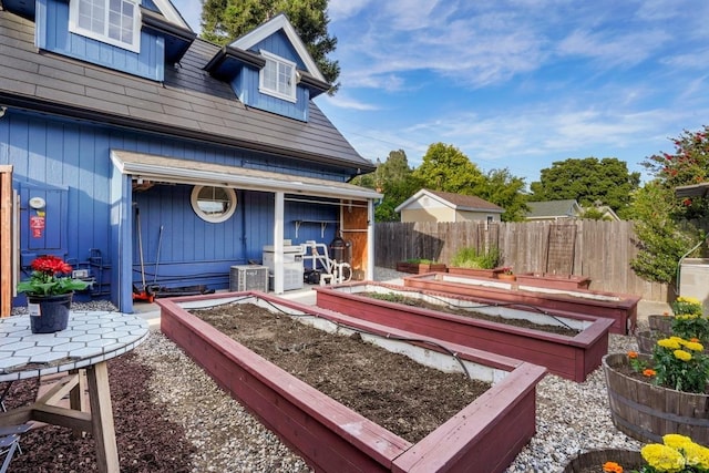 view of yard with central AC unit, a garden, and fence