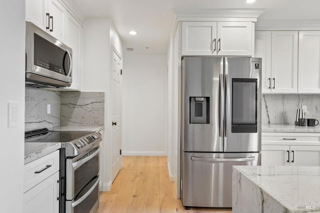 kitchen featuring white cabinetry, stainless steel appliances, recessed lighting, and decorative backsplash