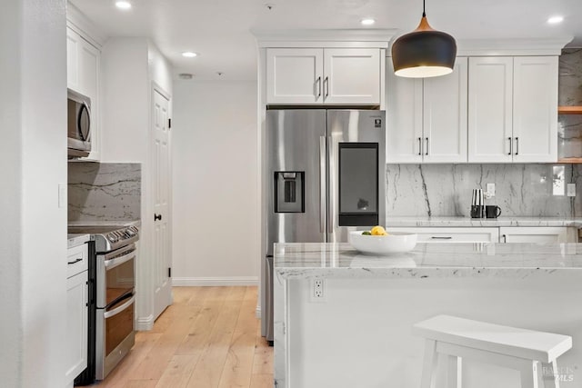 kitchen with recessed lighting, light stone counters, white cabinetry, stainless steel appliances, and tasteful backsplash