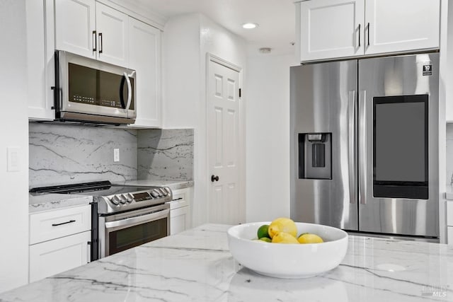 kitchen with stainless steel appliances, light stone counters, recessed lighting, backsplash, and white cabinets