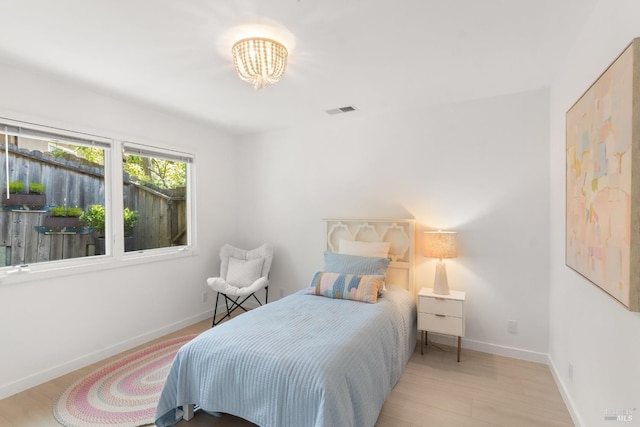 bedroom with a chandelier, baseboards, and wood finished floors