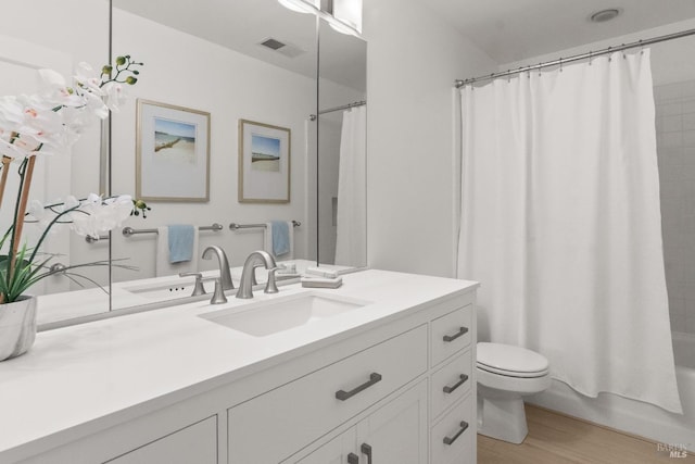 bathroom featuring wood finished floors, vanity, toilet, and shower / bathtub combination with curtain