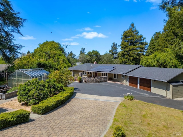 7301 Baker Ln, Sebastopol, CA 95472 - single story home with an exterior structure, driveway, solar panels, an outdoor structure, and an attached garage