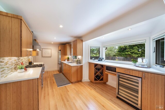 7301 Baker Ln, Sebastopol, CA 95472 - kitchen with beverage cooler, under cabinet range hood, decorative backsplash, light wood finished floors, and light countertops