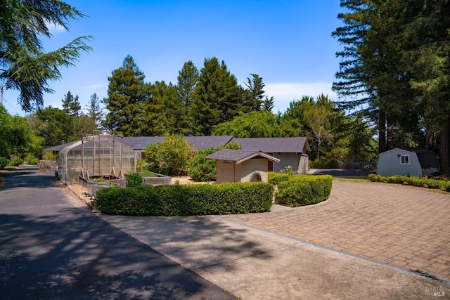 7301 Baker Ln, Sebastopol, CA 95472 - view of front of property with a greenhouse, an outdoor structure, decorative driveway, and a garden