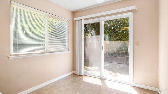 doorway to outside featuring baseboards and ceiling fan