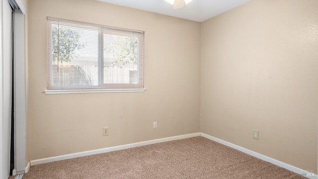 spare room featuring carpet floors, baseboards, and a ceiling fan