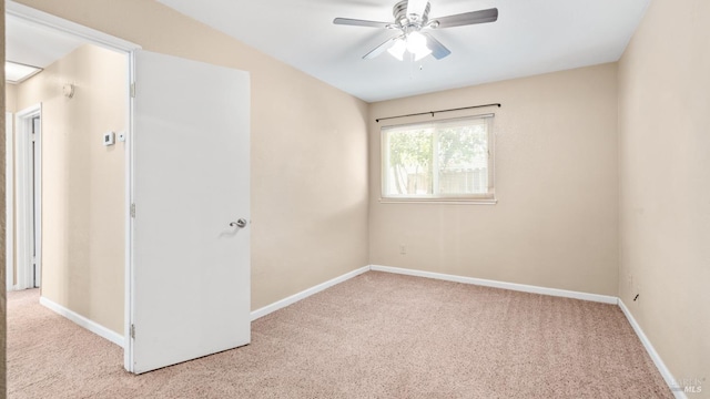 spare room featuring carpet, ceiling fan, and baseboards