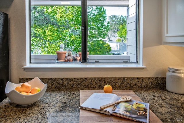 detailed view of white cabinets and a textured wall