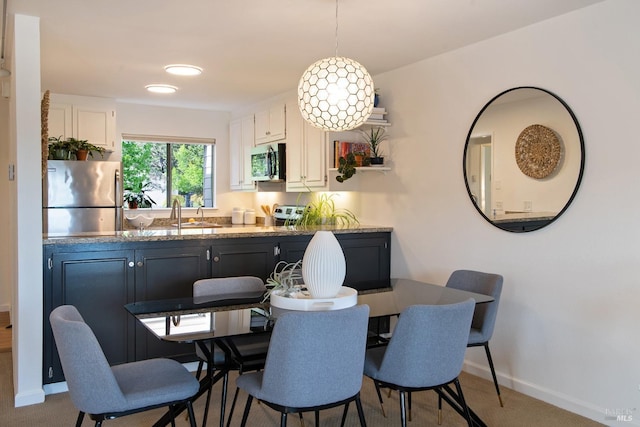 dining space featuring baseboards and carpet flooring