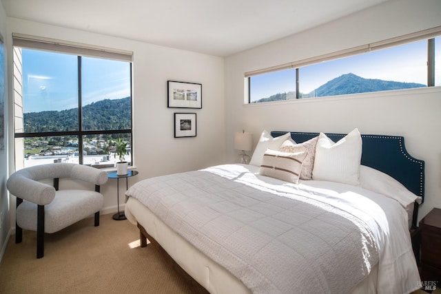 carpeted bedroom featuring a mountain view and baseboards