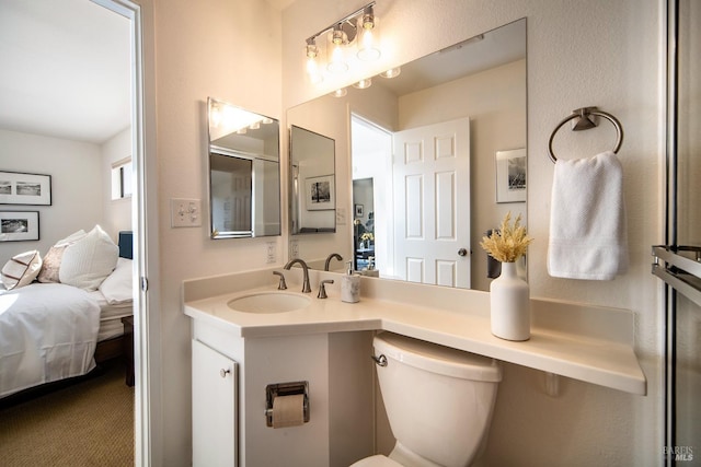 bathroom with ensuite bathroom, toilet, and vanity