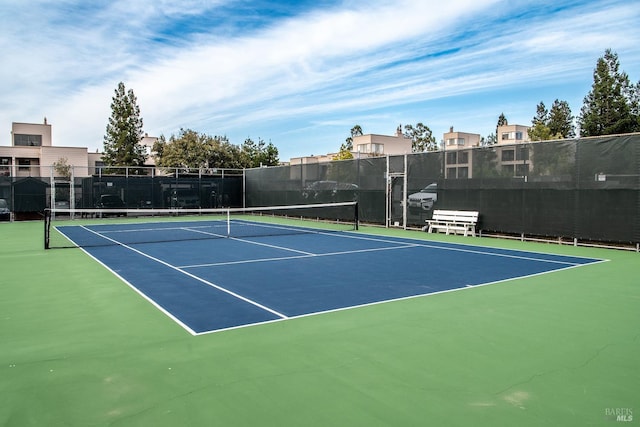 view of tennis court featuring fence and community basketball court