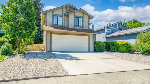 traditional-style house with driveway, a garage, and fence