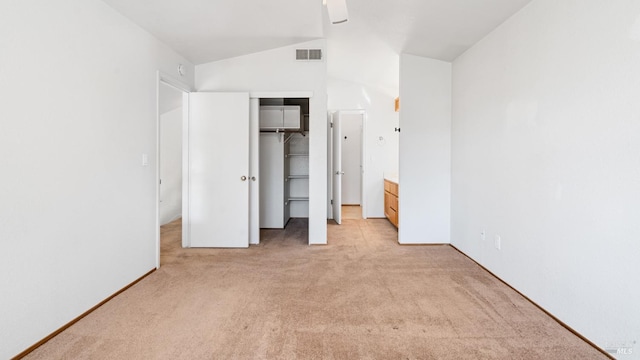 unfurnished bedroom featuring light carpet, vaulted ceiling, a closet, a ceiling fan, and baseboards