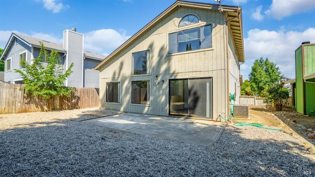 rear view of house with a patio, a fenced backyard, central AC, and a chimney