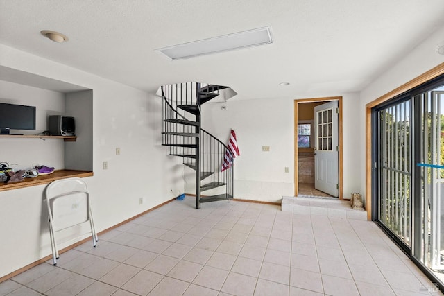unfurnished living room featuring stairs and baseboards