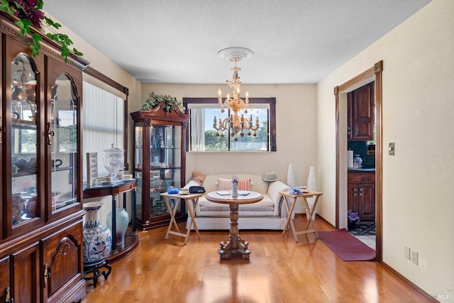 dining area with light wood-type flooring and a chandelier