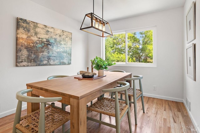 dining room featuring baseboards and light wood-style flooring