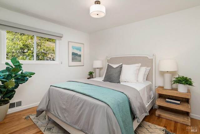 bedroom featuring wood finished floors and baseboards