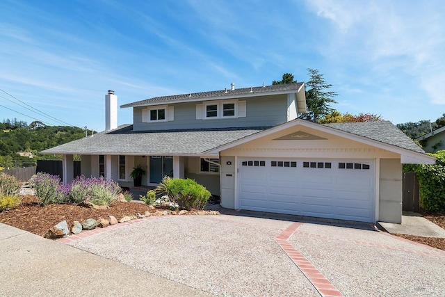 view of front of house with driveway, roof with shingles, fence, an attached garage, and a chimney