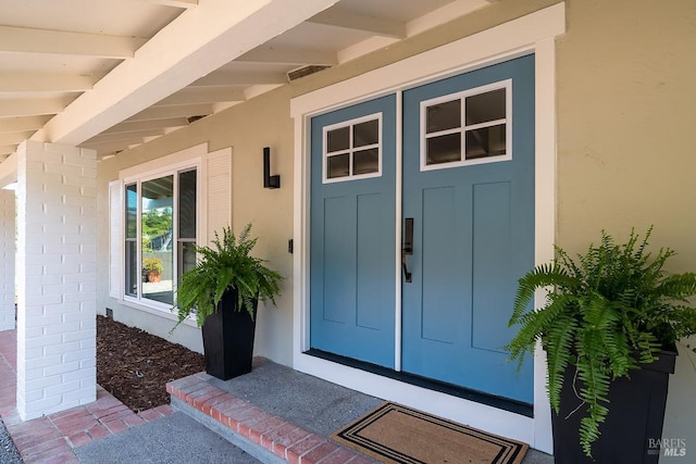 view of exterior entry with stucco siding