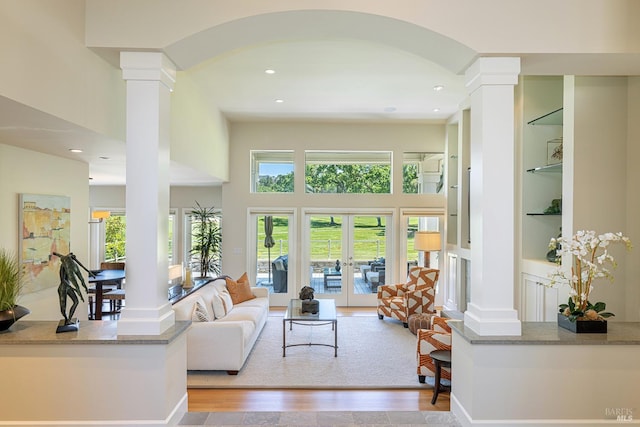living area featuring ornate columns, built in features, arched walkways, recessed lighting, and french doors