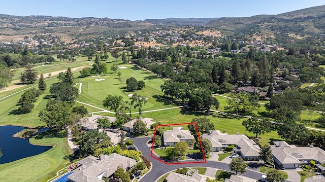 aerial view of residential area featuring a water and mountain view, property parcel outlined, and a golf course