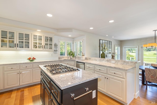 kitchen with appliances with stainless steel finishes, healthy amount of natural light, white cabinetry, light wood-style flooring, and recessed lighting