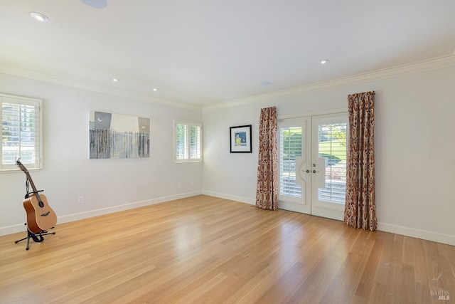unfurnished room with crown molding, french doors, light wood-style flooring, healthy amount of natural light, and baseboards