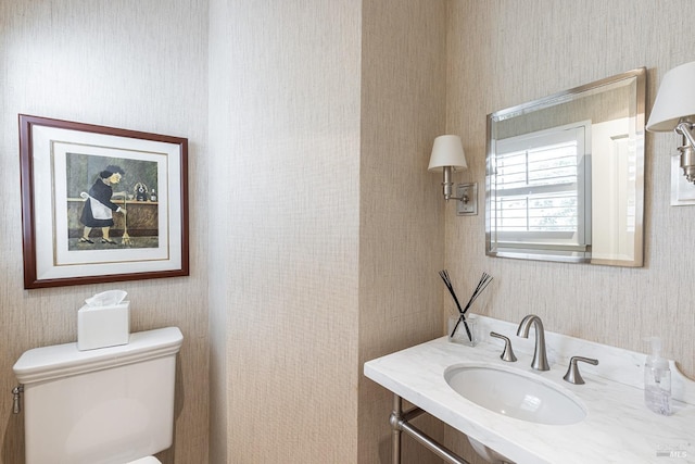 bathroom featuring wallpapered walls, toilet, and vanity