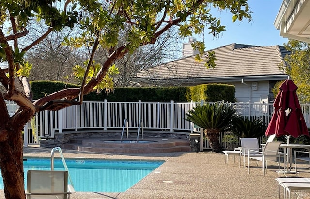 community pool with a patio and fence