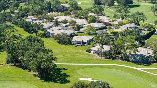 aerial view of property's location with a golf course and nearby suburban area