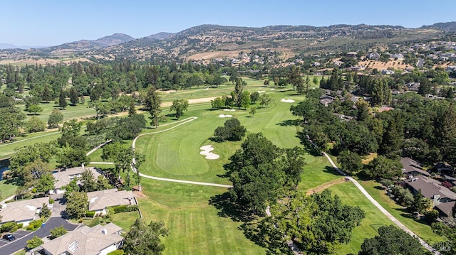 aerial overview of property's location featuring a mountainous background, nearby suburban area, and a golf course