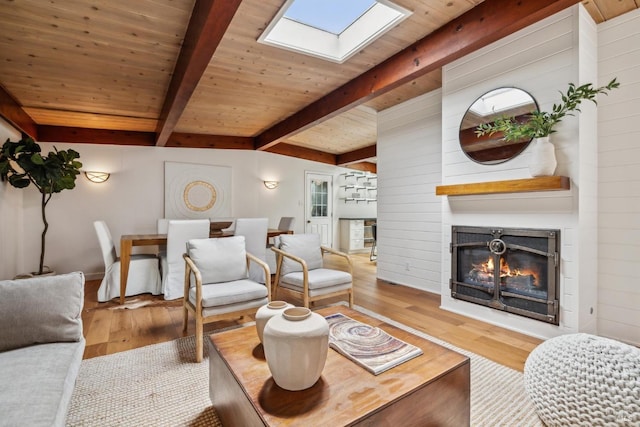 16 Ivy Ln, Woodacre, CA 94973 - living room featuring a glass covered fireplace, a skylight, wood finished floors, wooden ceiling, and wooden walls