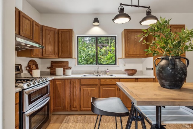 16 Ivy Ln, Woodacre, CA 94973 - kitchen with double oven range, a sink, under cabinet range hood, brown cabinetry, and light wood-style flooring