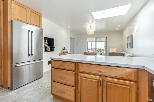 kitchen featuring freestanding refrigerator, a skylight, and light countertops