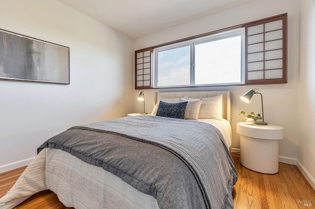bedroom with baseboards and wood finished floors