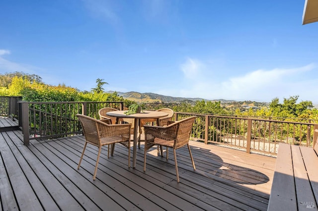 wooden terrace with a mountain view and outdoor dining area